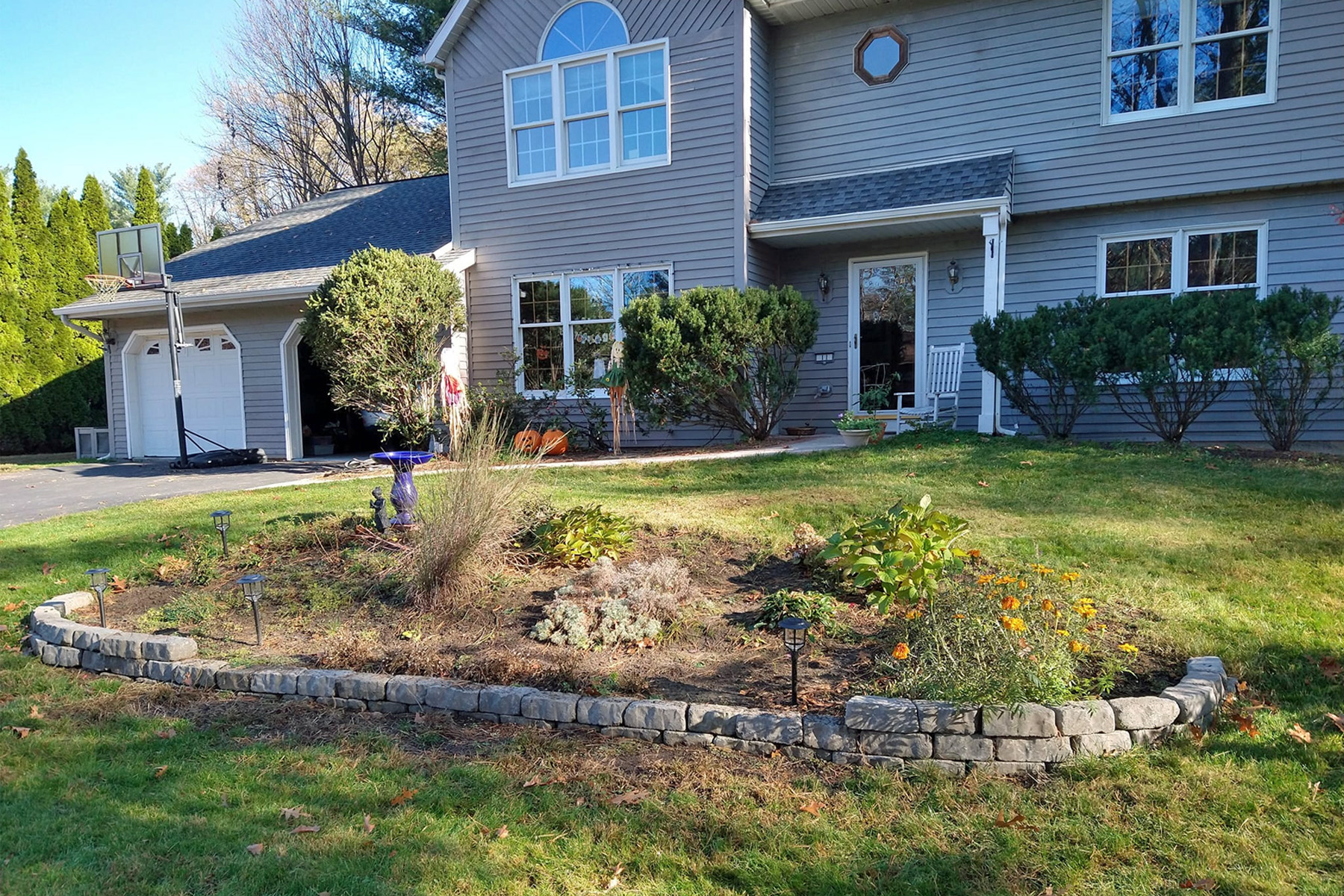 Thumbnail of after image of completed plant bed with mulch, stone, and newly planted trees
