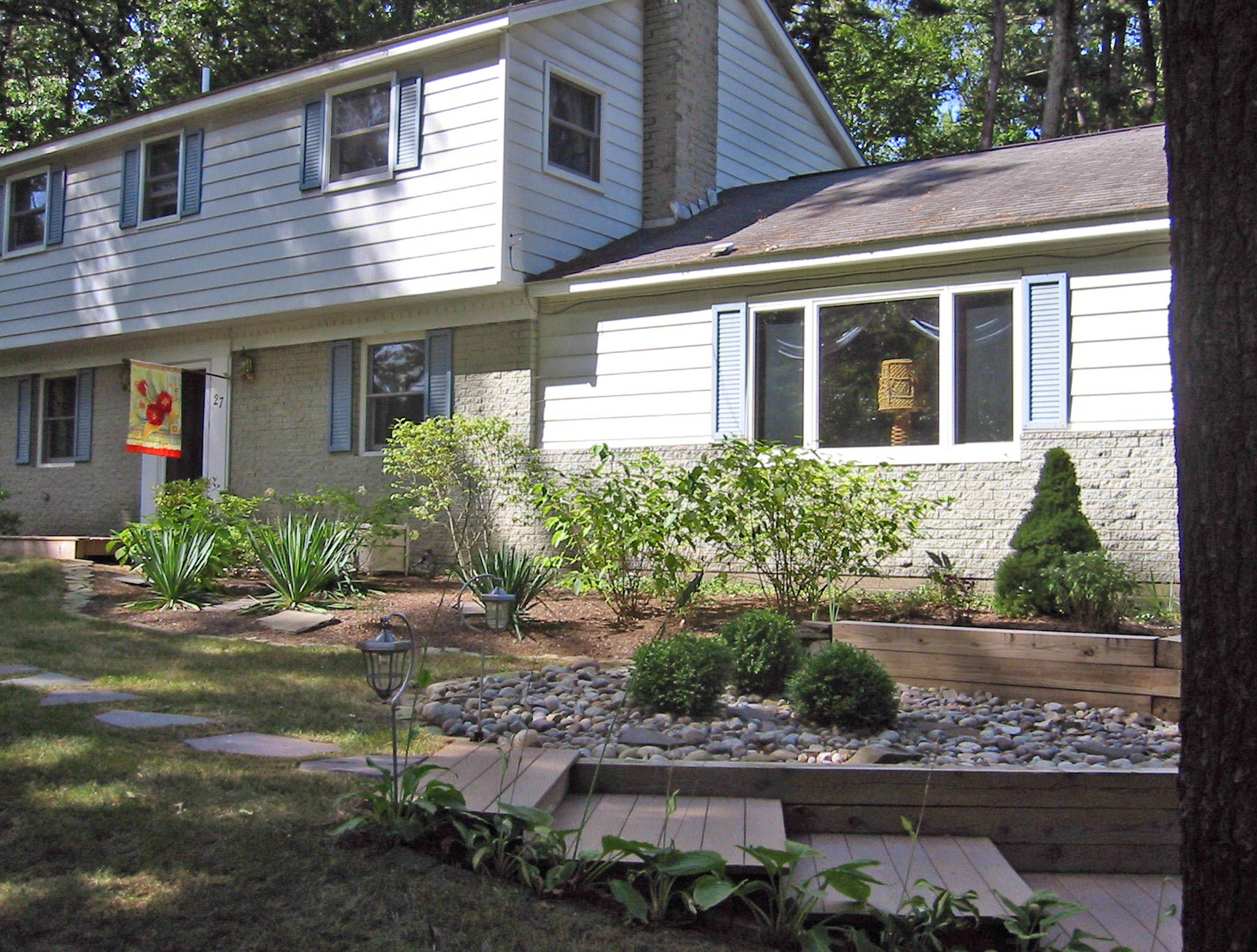 After image of front yard with new plant beds, stone, and stairways