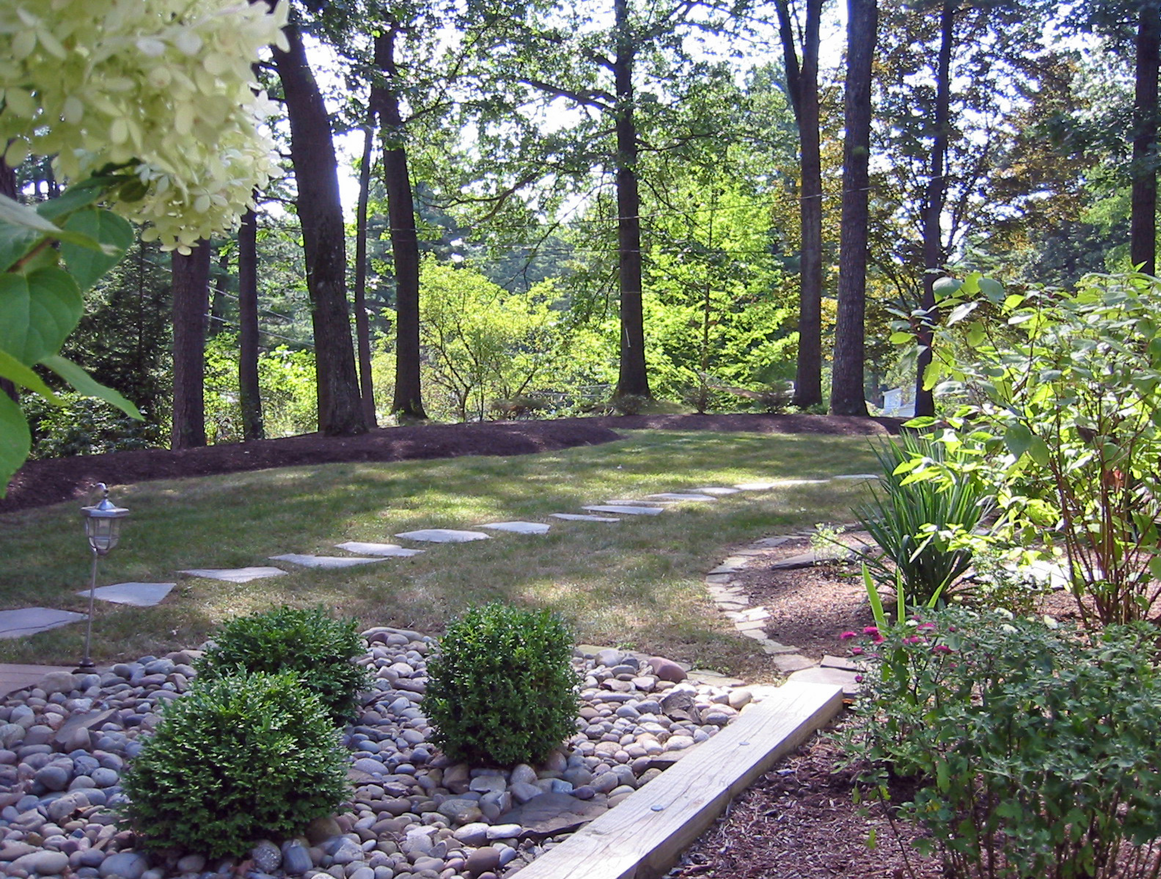 After image of front yard with new plant beds, stone, and stairways