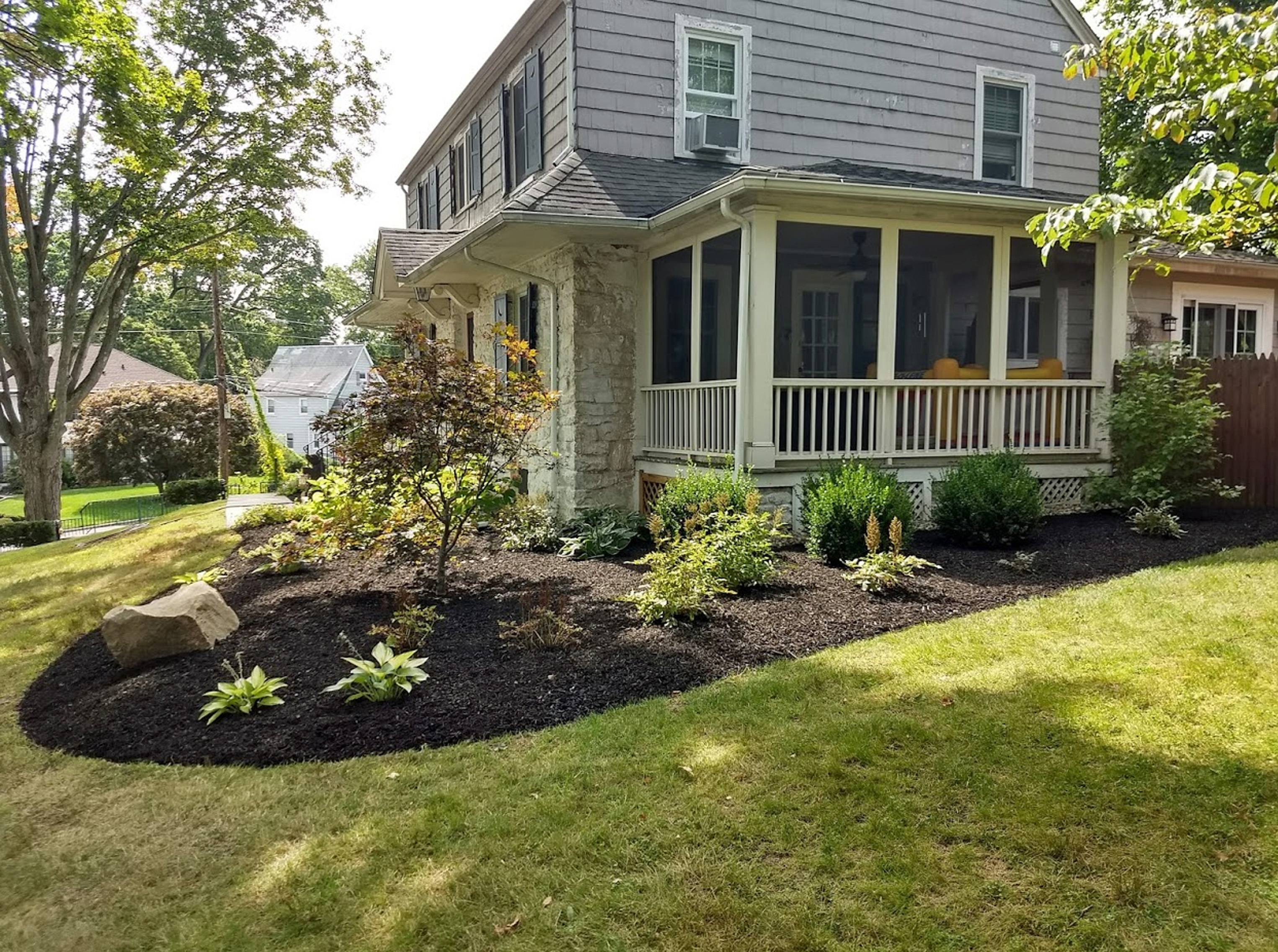 Thumbnail of completed plant bed, on the corner, with mulch and edging