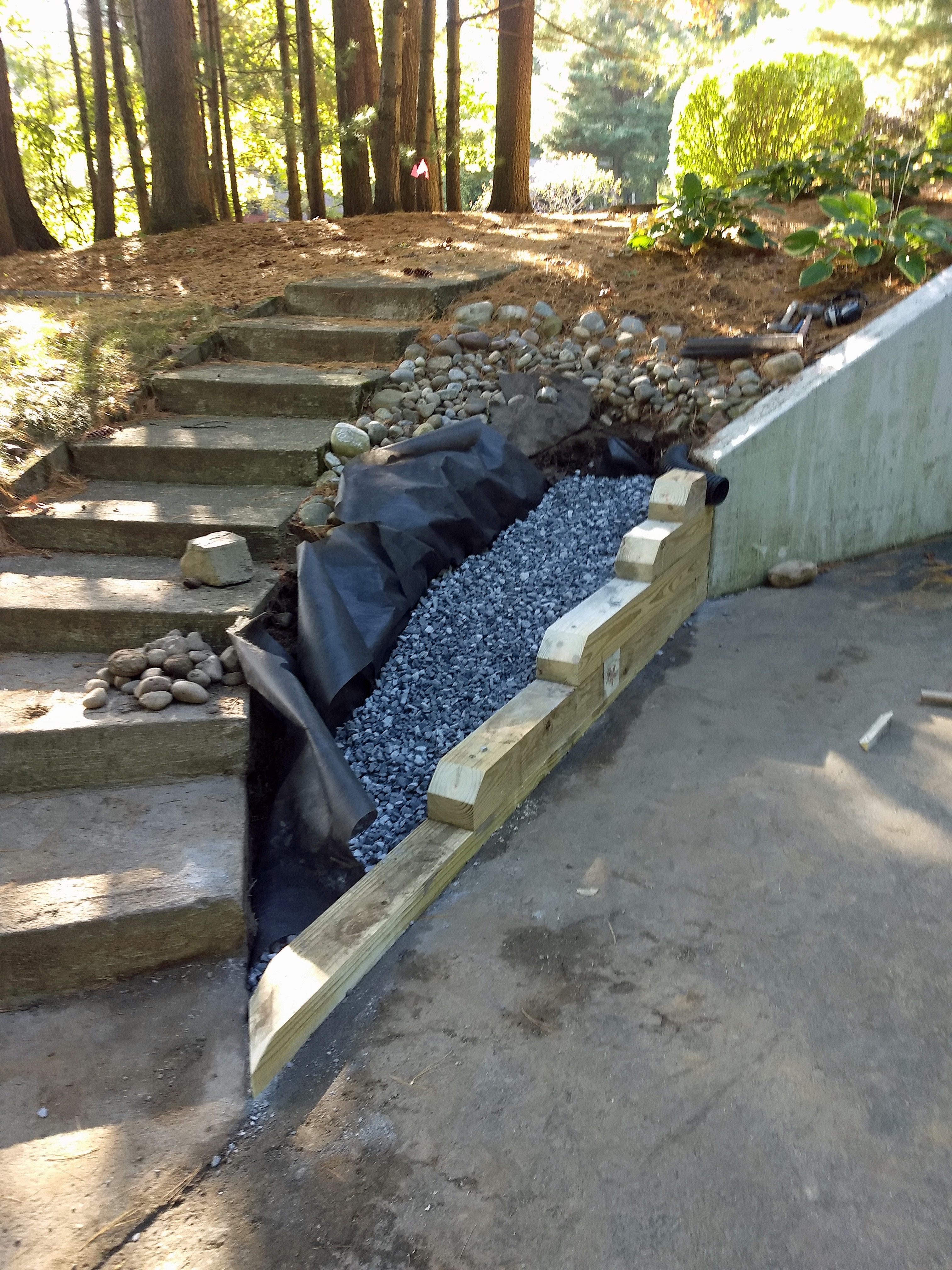 Thumbnail of the new wooden retaining wall, stone, and landscaping fabric in place