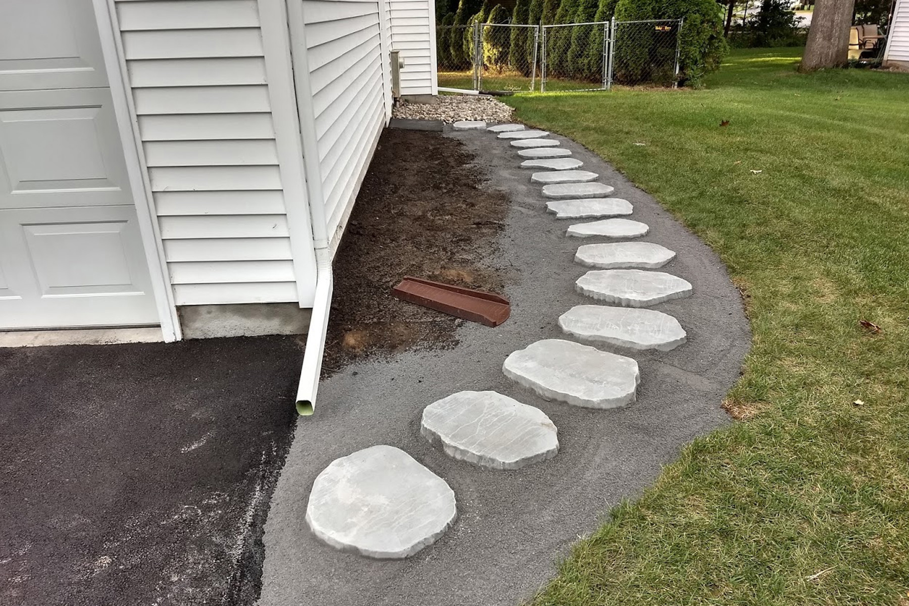 The pavers are set in sand along the side of the garage