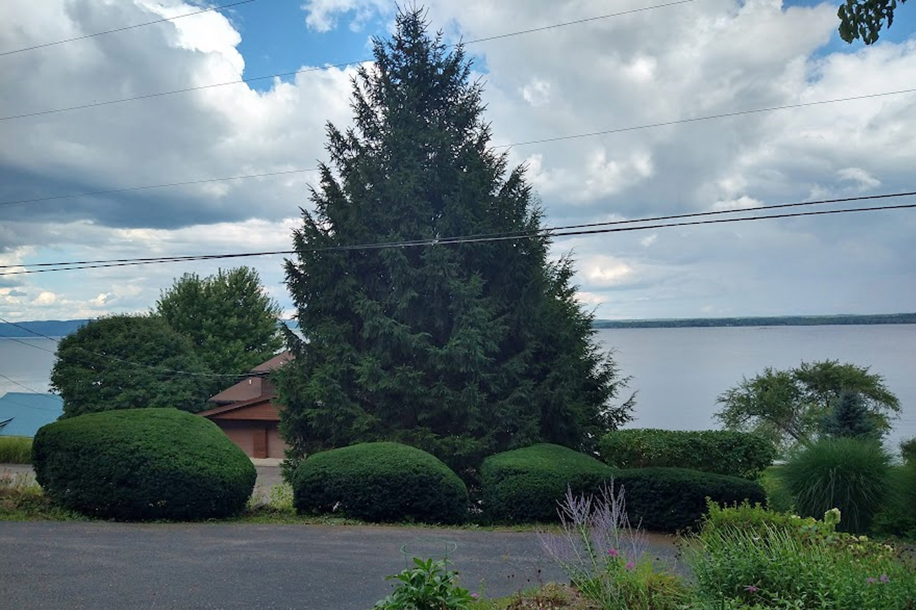 Thumbmnail image of a freshly mowed lawn with work truck and trailer holding a lawn mower