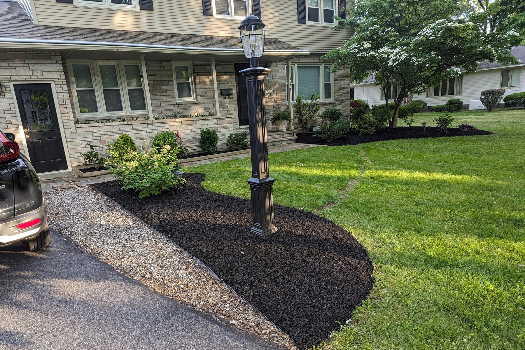Thumbnail of a freshly weeded stone retaining wall with fresh tree mulch beds