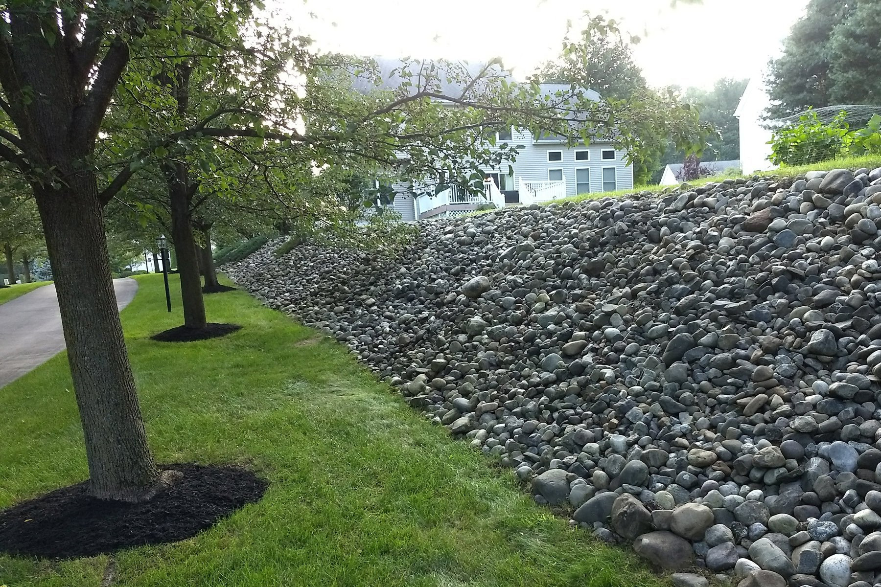 Thumbnail of a freshly weeded stone retaining wall with fresh tree mulch beds